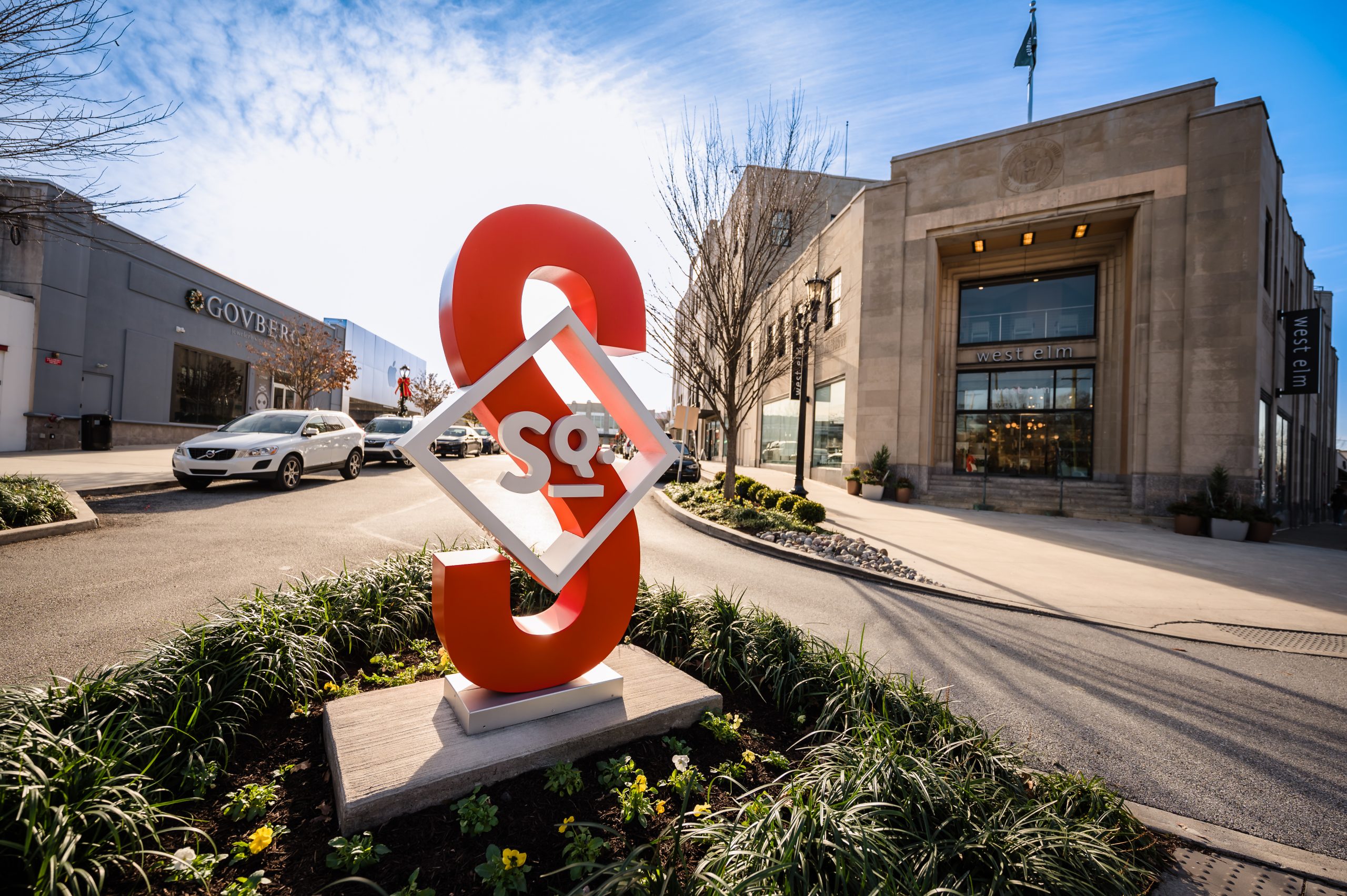 The modern Suburban Square logo monument at the town center entrance